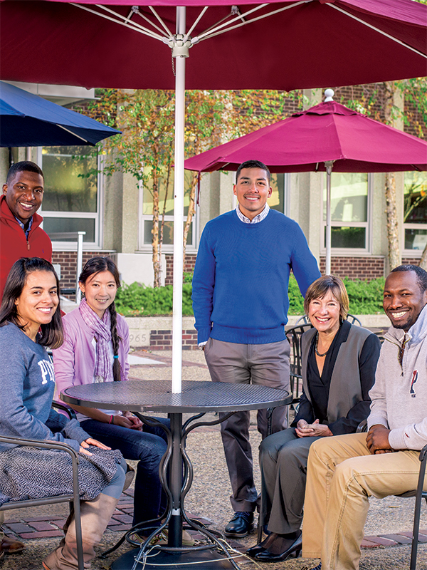 Dean and students around table outdoors in Penn GSE courtyard