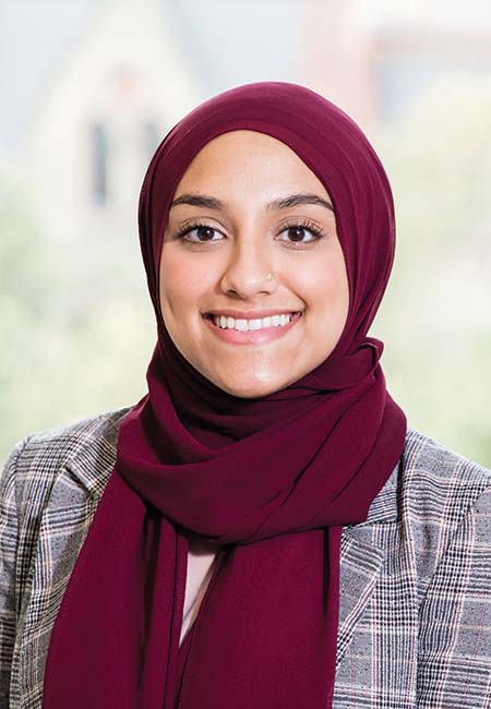 Headshot of Shahara Ahmed wearing a maroon head covering against a blurred backdrop.