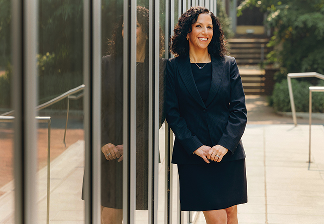 Penn GSE Dean Katharine Strunk poses outside against a glass façade