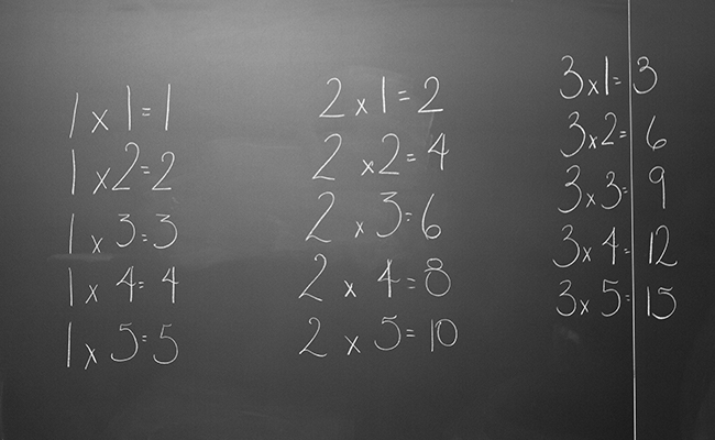 Basic multiplication written in chalk on a blackboard.