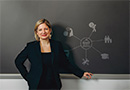 Penn GSE Associate Professor Brooks Bowden leaning against a chalkboard