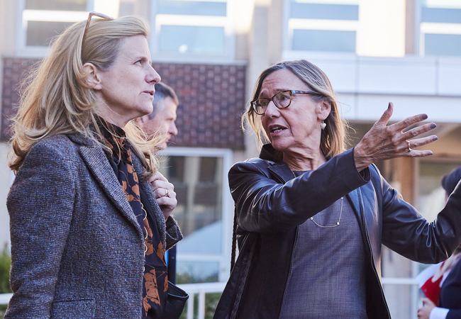 Dean Pam Grossman and President Liz Magill stand outside the Penn GSE building expansion project on a tour as the dean gestures at the construction.