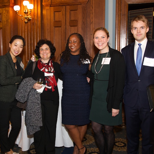 One male and four female GSE alumni standing together and smiling at cocktail  party.