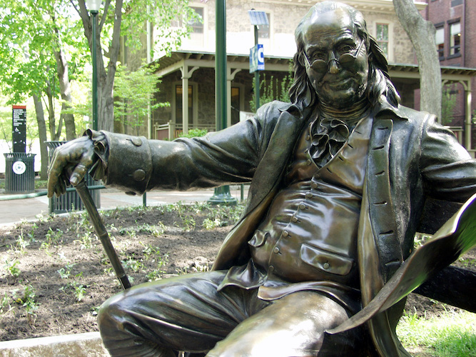 Statue of Benjamin Franklin sitting on a bench