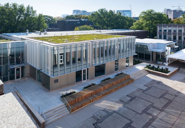 A view of the 2023 courtyard and lobby additions to the Penn GSE building from above, showing their green roofs and rear facade