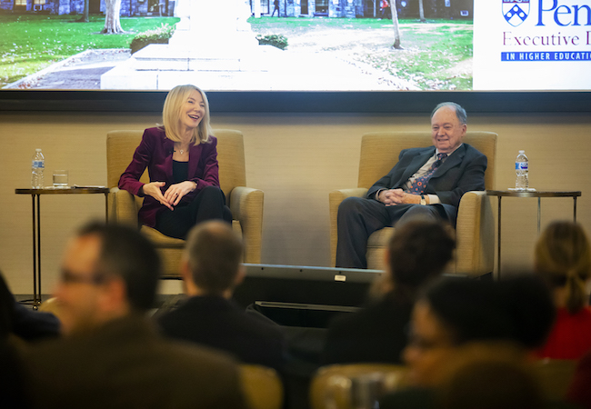 Penn President Amy Gutmann and professor Robert Zemsky talk on a stage.