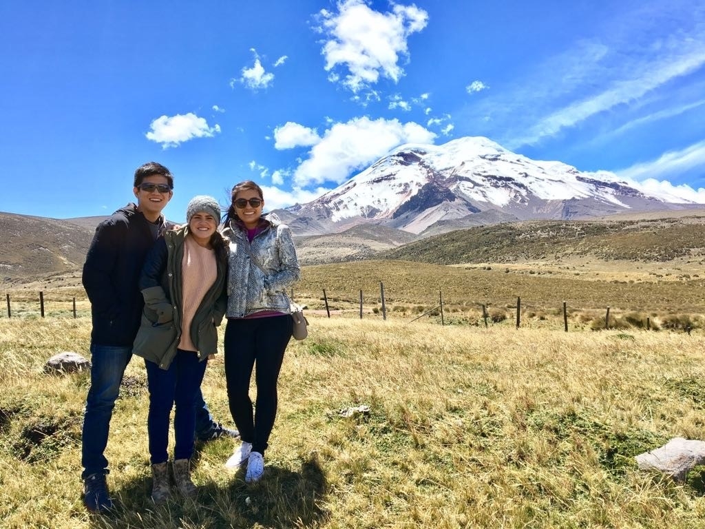 Trio posing with mountain in background.