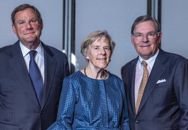 The McGraw siblings , Robert, Suzanne, and Harold III , stand together smiling.