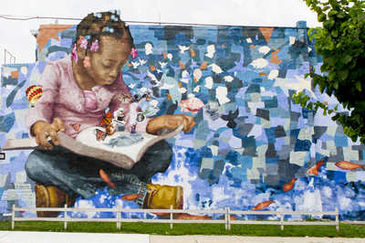 Mural of a young person reading.