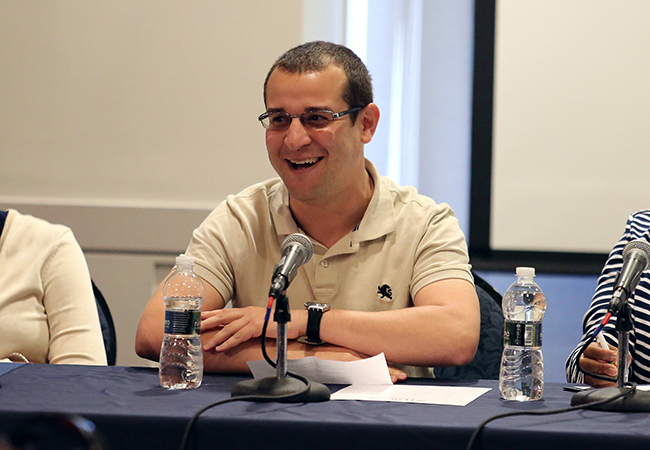 Man with glasses at table with microphone