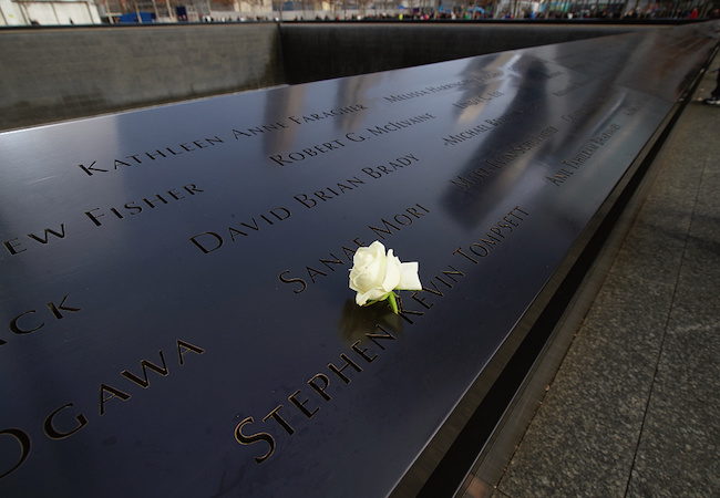 A white rose is left inside an engraved name at the 9/11 memorial in New York City.