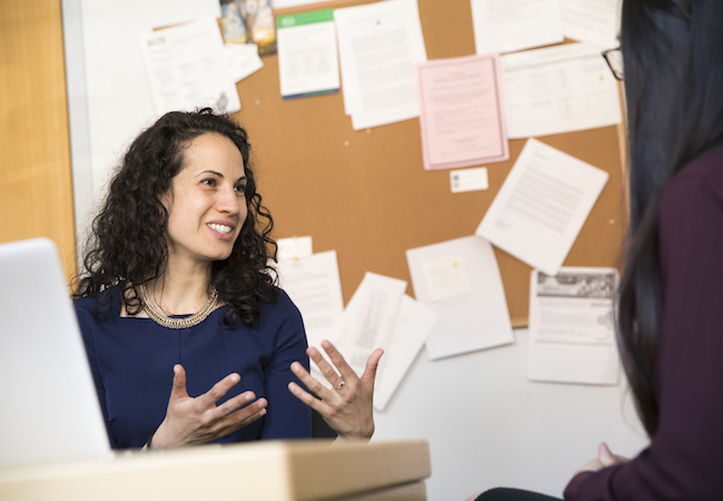 Sharon Wolf talks with a student in her office. 