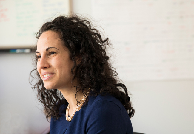 A headshot of Sharon Wolf smiling in profile in her classroom.