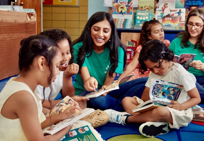 Start Lighthouse founder and Penn GSE alum Rina Madhani in a classroom, reading to elementary school students sitting in a circle