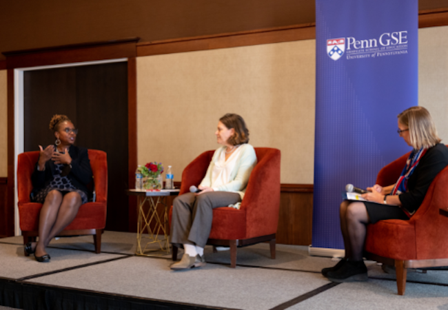 Professors Andrea Kane and Sigal Ben-Porath seated on stage with Dean Pam Grossman during a recent panel discussion about free speech. Dr. Kane is speaking and the other two panelists are looking at her intently.