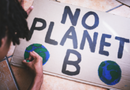 A student making a poster that says "No Planet B"