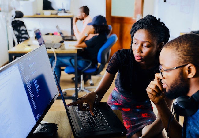 Two people looking at a computer screen.