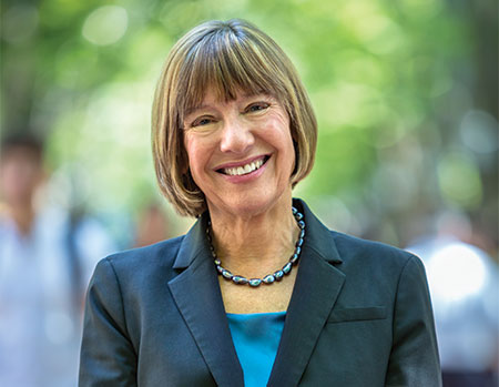 Headshot of Dean Pam Grossman in a dark jacket and blue blouse on Locust Walk