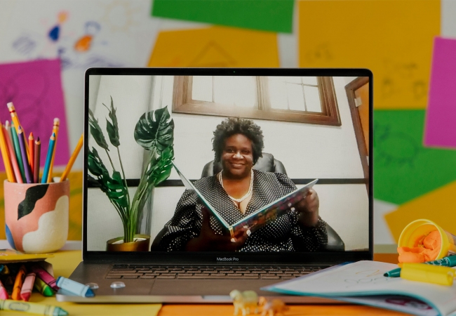 a teacher reads a book in a virtual classroom