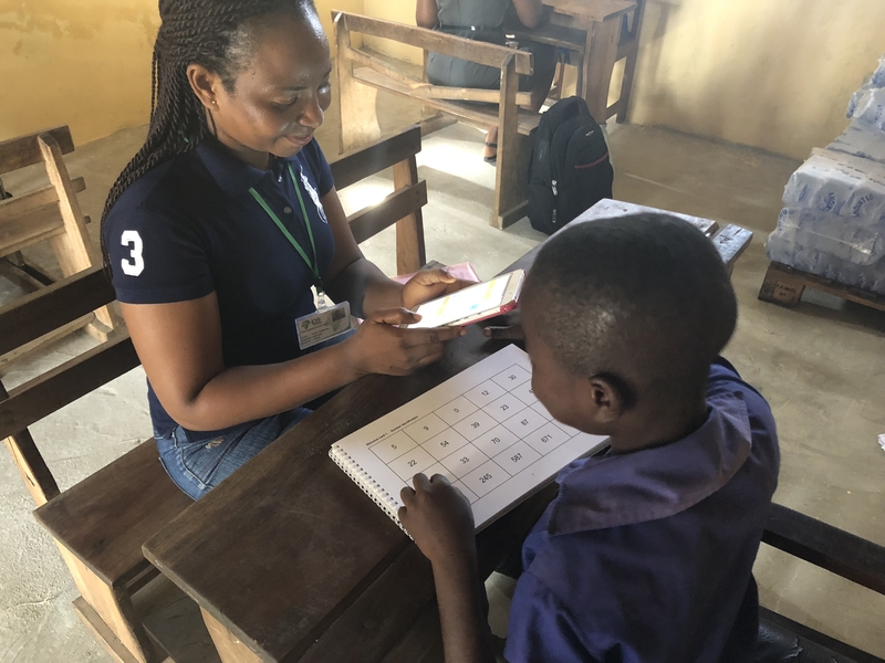 A teacher works with a student in Ghana.