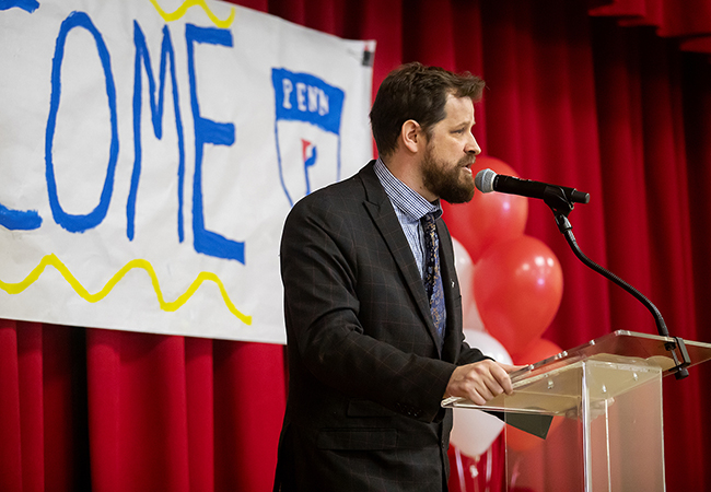 Lea School principal Aaron Gerwer speaks from behind podium at celebration event.