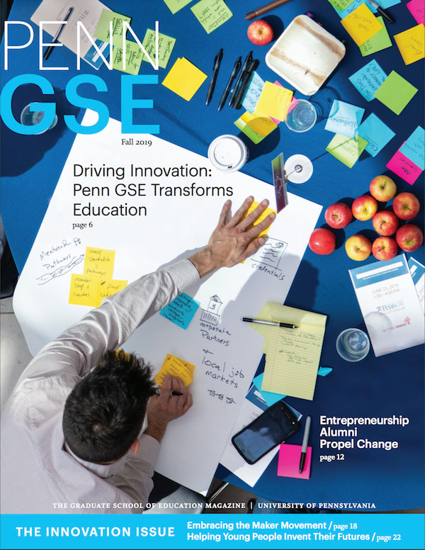 The cover of the Fall 2019 issue of The Penn GSE Magazine. It shows an aerial view of a person writing on sticky notes and a large piece of white paper on a blue tabletop. The table is covered with colorful sticky notes, apples, and pens. Headlines read “Driving Innovation: Penn GSE Transforms Education,” “Entrepreneurship Alumni Propel Change,” “Embracing the Maker Movement,” and “Helping Young People Invent Their Futures.” A blue bar at the bottom says “The Innovation Issue.”