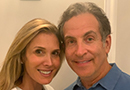 Headshot of a smiling man and woman leaning their heads together. 