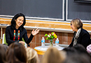 Angela Duckworth and Dean Grossman sit opposite each other conversing before an audience
