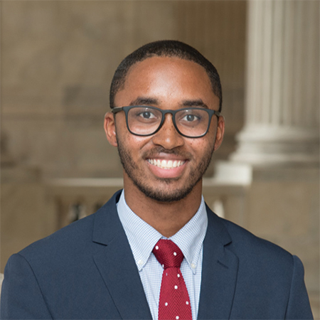 Headshot of D’Andre McIntyre in front of a building with white columns