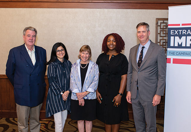 Five Penn GSE faculty wearing business attire stand next to each other and smile