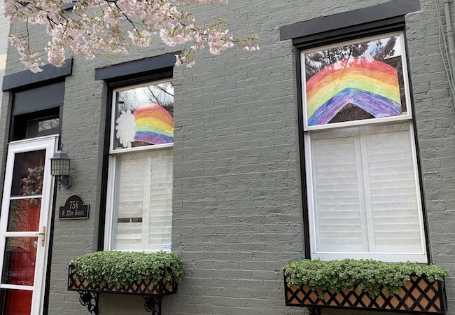 A house with drawings of rainbows in the window. 