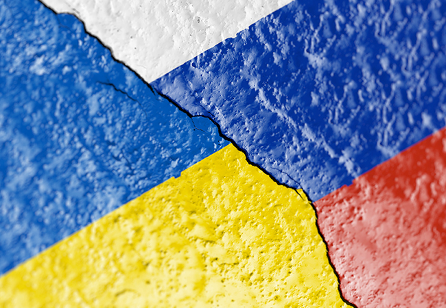 Cracked pavement with the Ukrainian and Russian flags painted on.