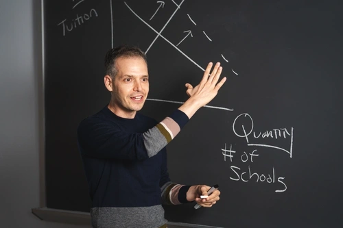 Michael A. Gottfried teaching in front of a blackboard