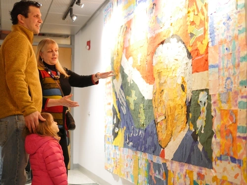 Three people admiring a mural of Nelson Mandela from the School District of Philadelphia