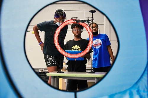 OSCE Summer Program Students flying a drone through obstacle course