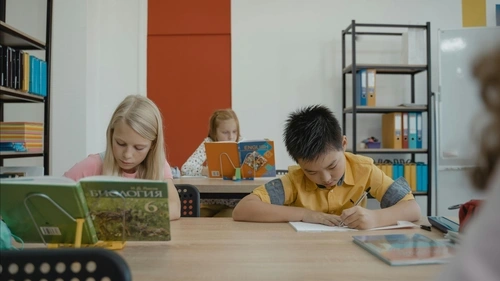 Elementary-age children writing at their desks