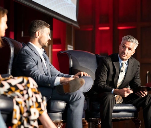 John Gamba at a panel discussion on stage with other people