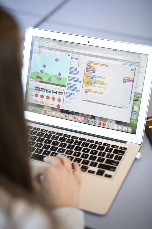 Student designing an online learning game on a laptop.