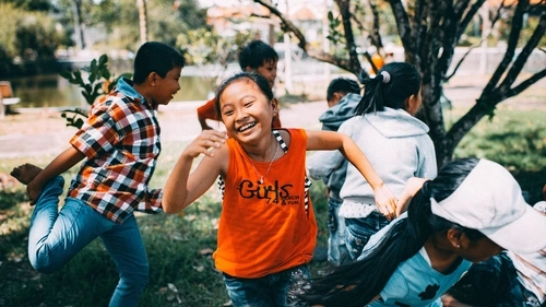 young female child smiling and running outside