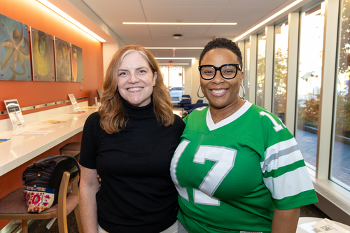 Jen McLaughlin Cahill and Njemele Anderson smile standing next to each other in Penn GSE's lobby