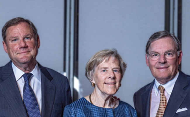 The McGraw siblings , Robert, Suzanne, and Harold III , stand together smiling.