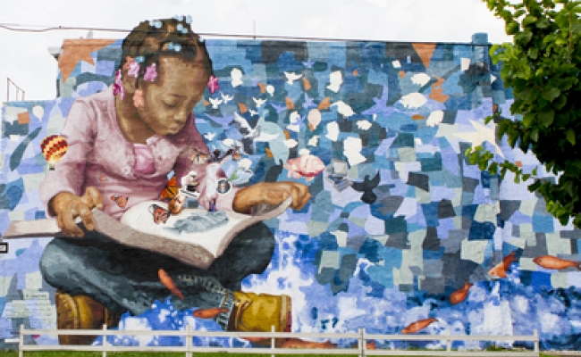 Mural of a young person reading.