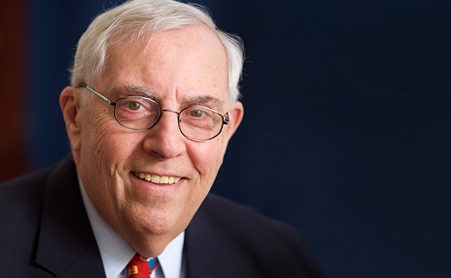 Smiling man with white hair and glasses