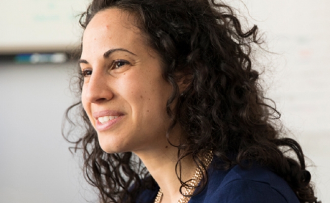 A headshot of Sharon Wolf smiling in profile in her classroom.