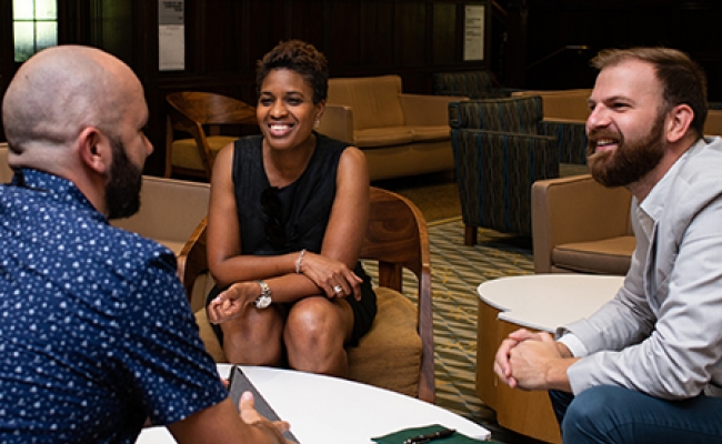 Penn GSE students sit in a lounge, conversing in a small group