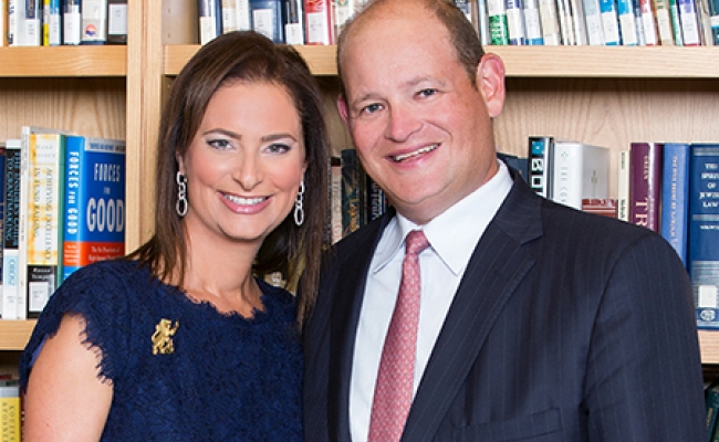 Smiling couple standing in front of a bookshelf