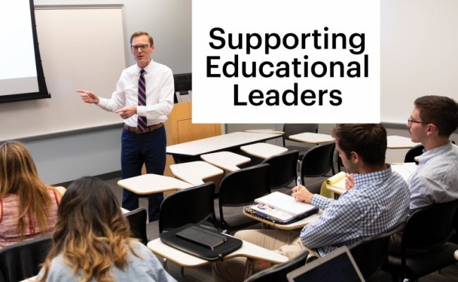 A professor wearing a white shirt and striped tie addresses a classroom of students who are listening and taking notes. The screen in the background has a large pi symbol] [Photo caption] Dr. Zachary Hermann is executive director of Penn GSE’s Center for Professional Learning, which offers virtual programs to support educators at various levels in the face of changing educational environments.