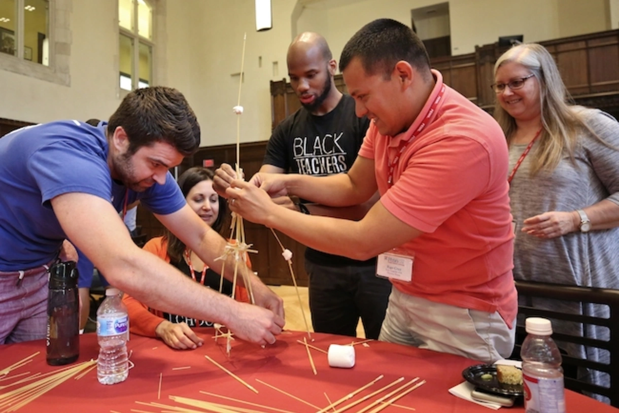 Students in a project-based learning certificate program class collaborate to find a solution to a problem. 