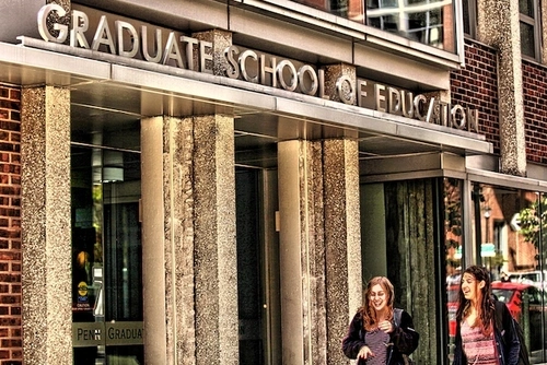 Two students walk in front of Penn GSE's building.