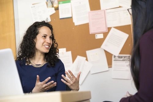 Sharon Wolf talks with a student in her office.